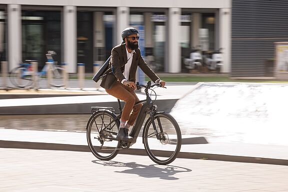 Ein Pendler fährt auf seinem elektrischen Fahrrad durch das Stadtgebiet. 
